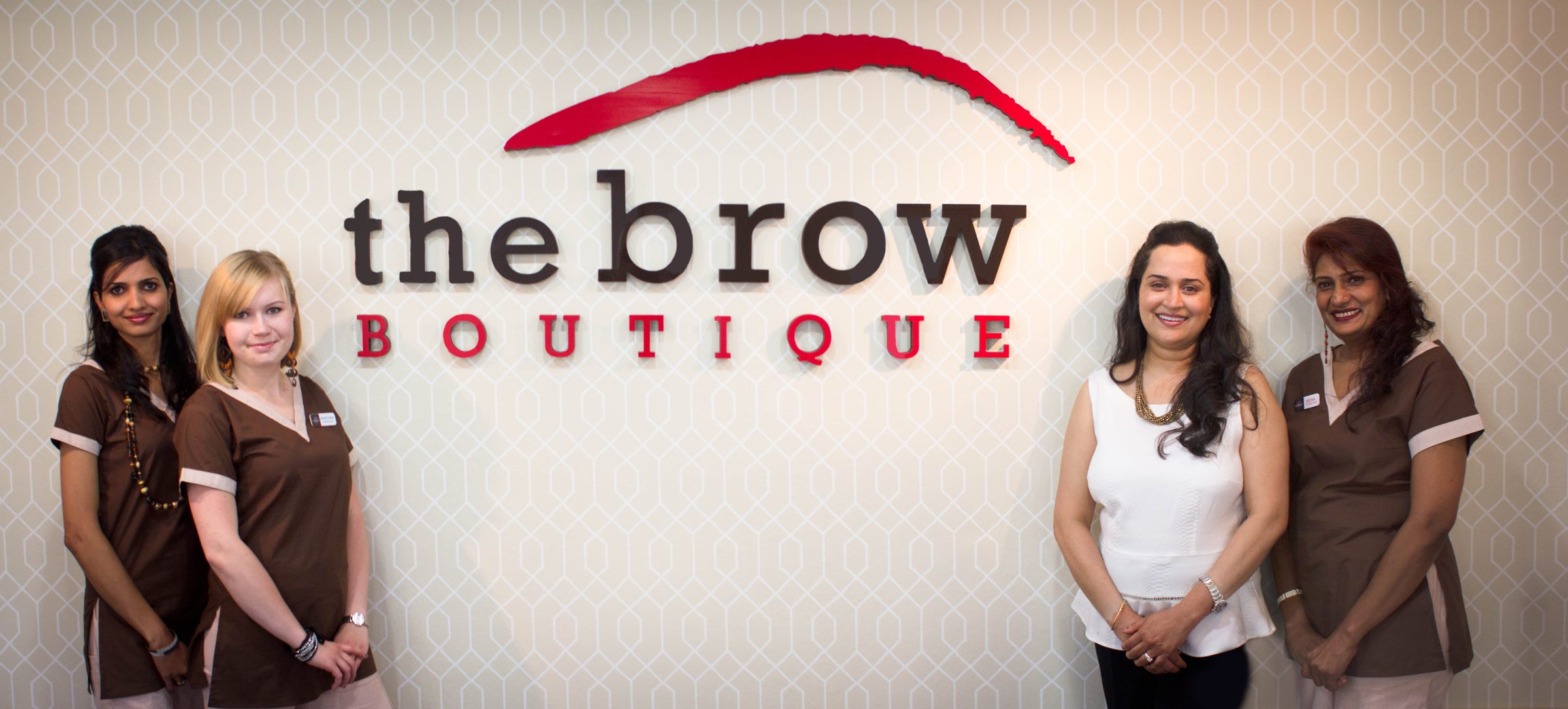 The Brow Boutique team in front of the boutique sign